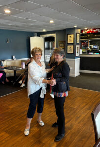 Two people dancing together at the Friendship Lunch event in Wakefield, enjoying a joyful moment during the community gathering.